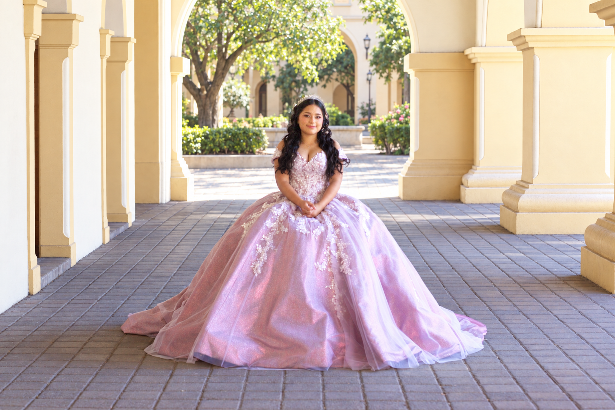 Caroll con vestido lila bajo una galería de arcos